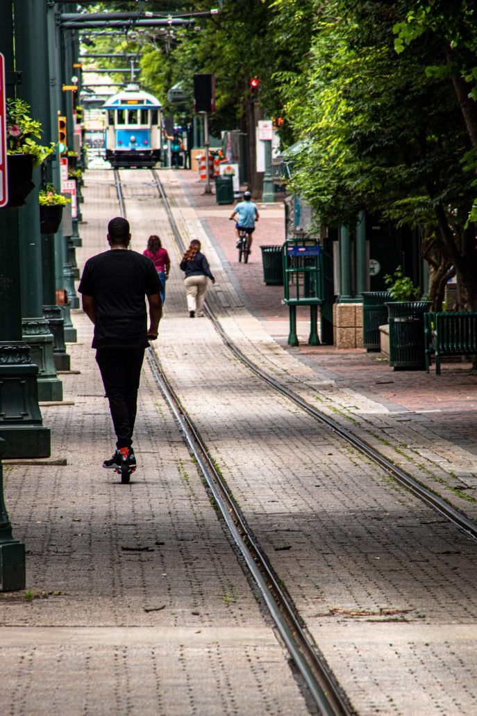 tramway with people walking, biking, and scooting along